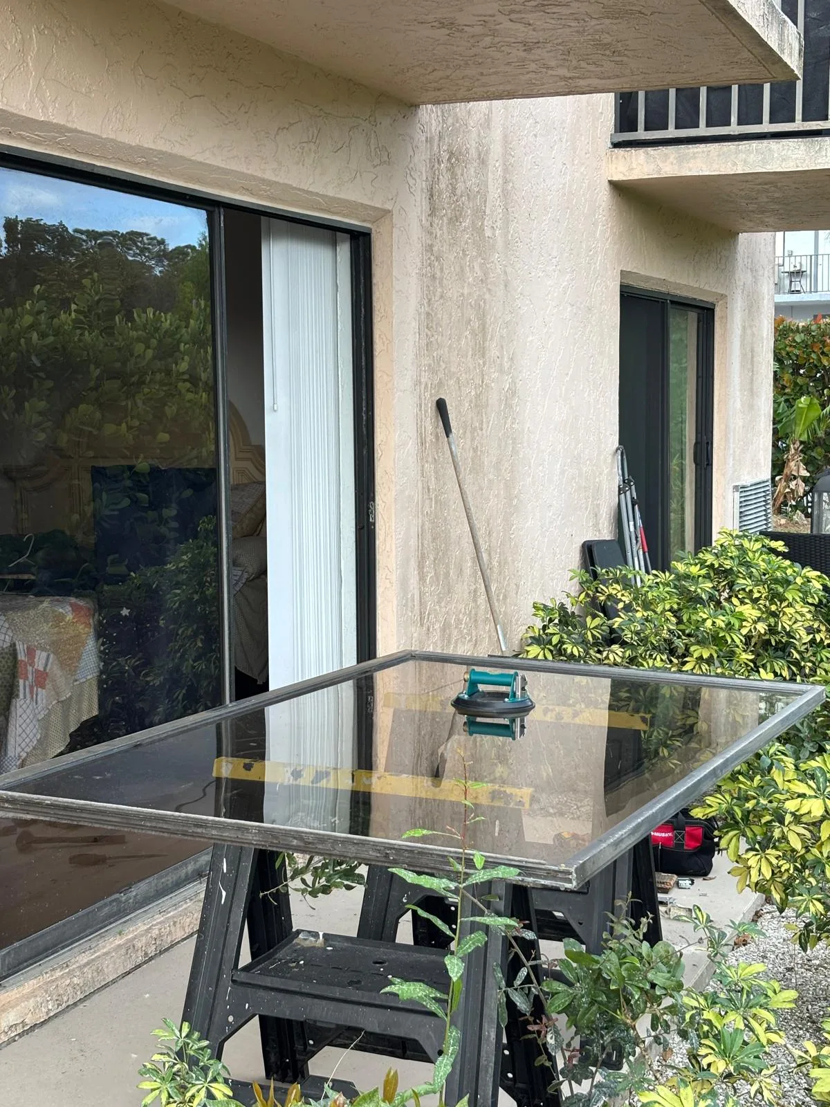 Sliding door panel set up on sawhorses for glass replacement