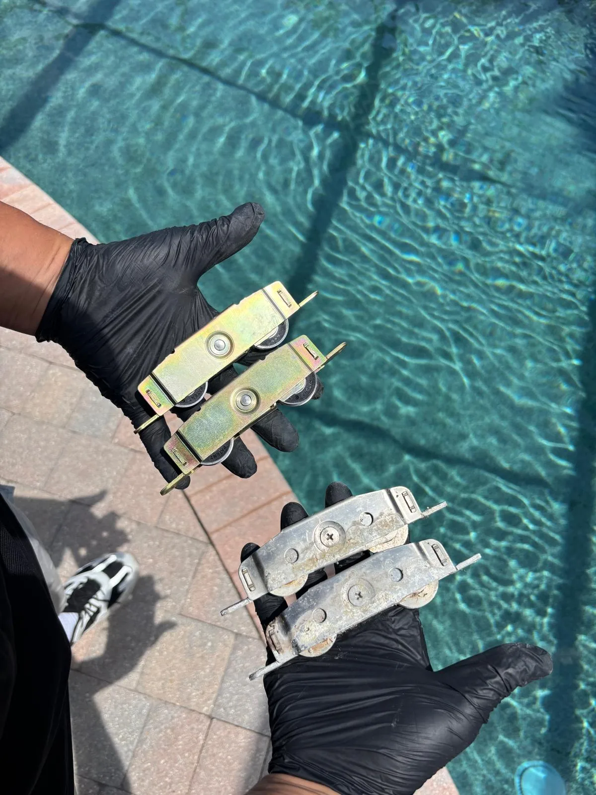 Close-up of a damaged sliding door roller with cracked wheel